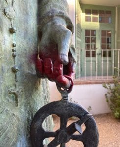 Closeup of red spray painted hand of Father Kino Statue outside Arizona History Museum