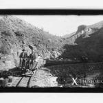 Two men sitting on the back of a railroad car